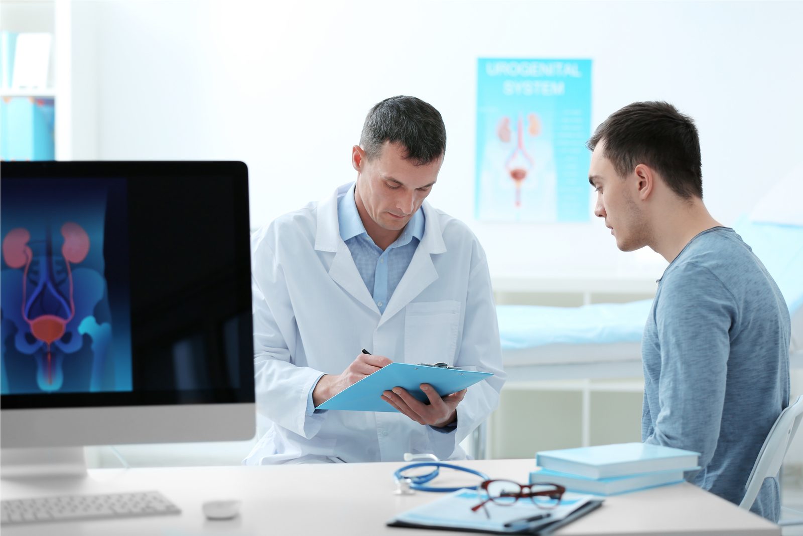 A urologist reviewing a patient's chart during a consultation